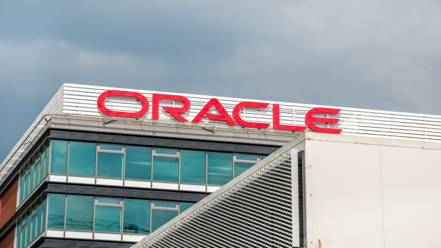 The Oracle logo is displayed on the exterior of a modern building with glass windows.
