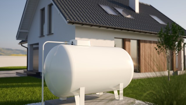 A white gas tank installed in front of a modern house.