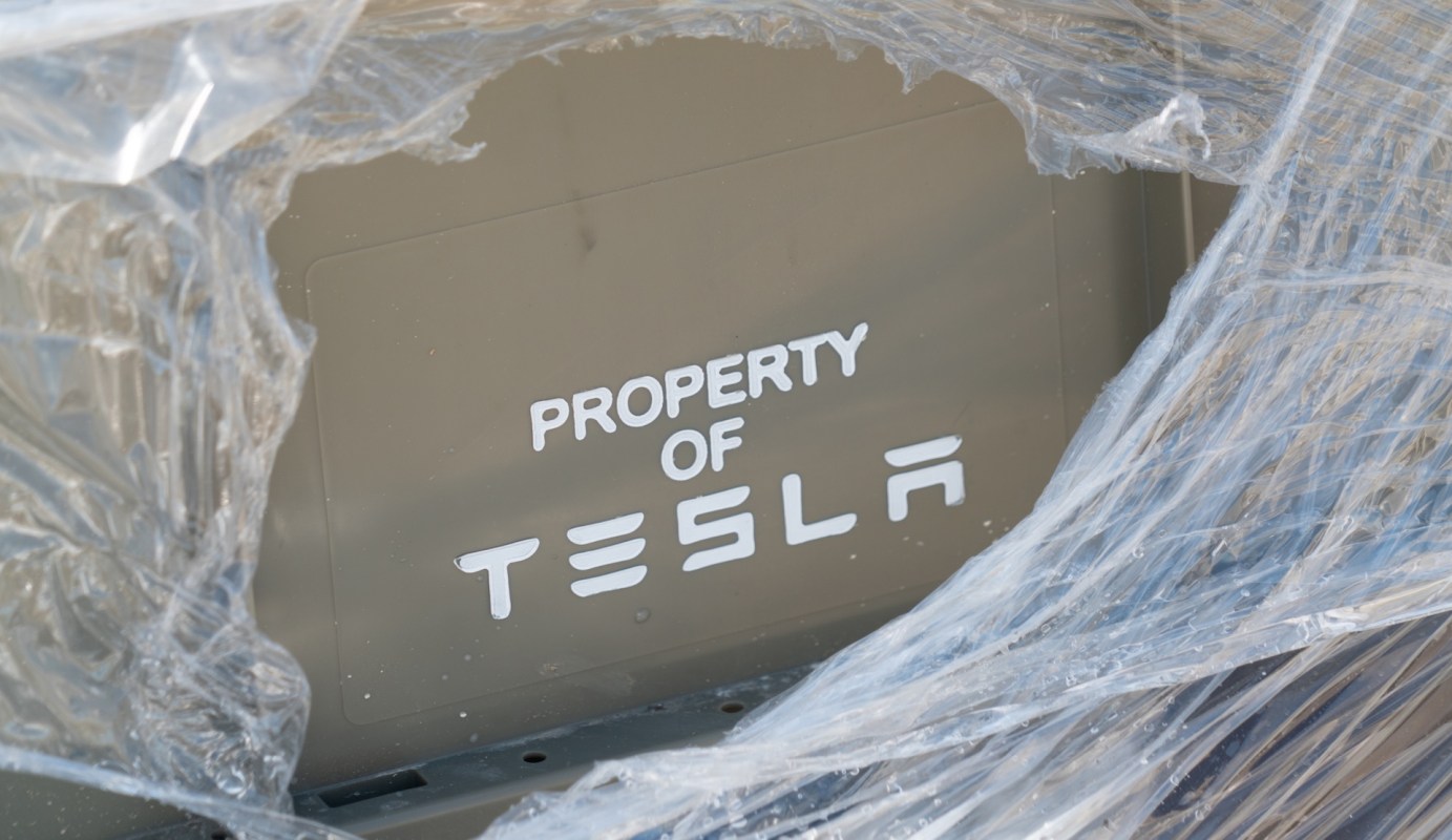 A partially wrapped object labeled "PROPERTY OF TESLA."