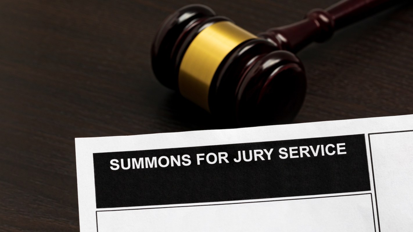 A jury summons document with a gavel in the background.