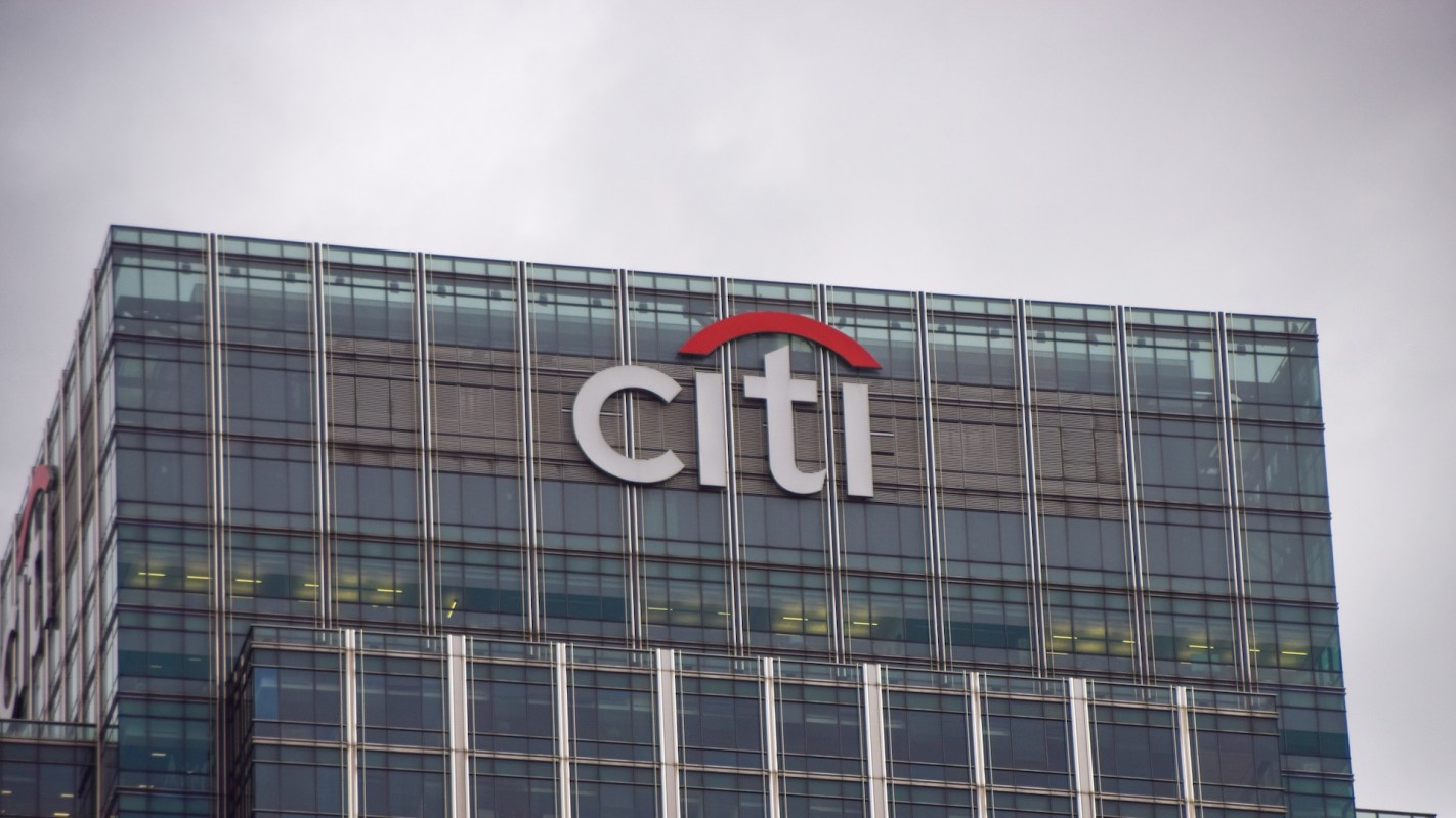 The top of a modern building featuring the Citi logo against a cloudy sky.