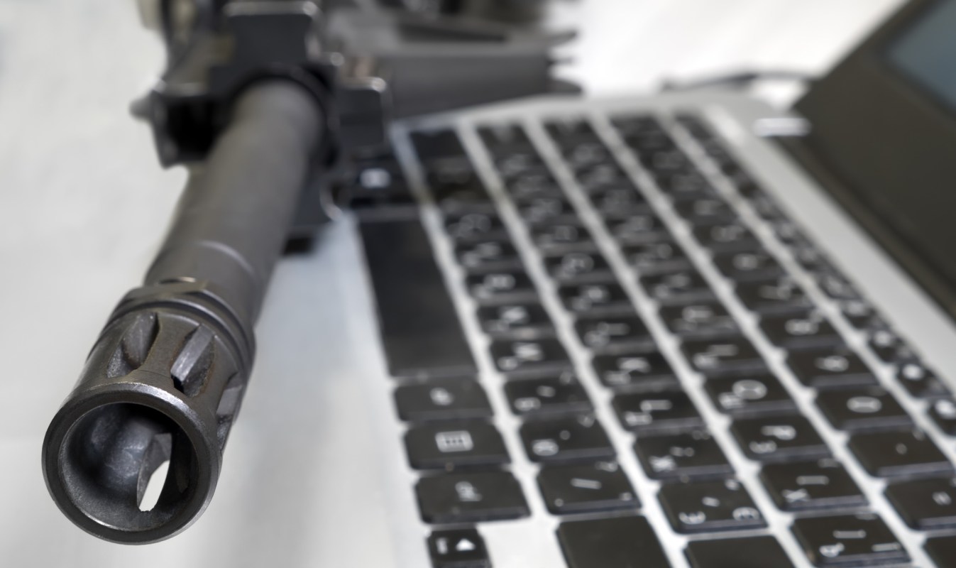 A gun on top of a laptop.