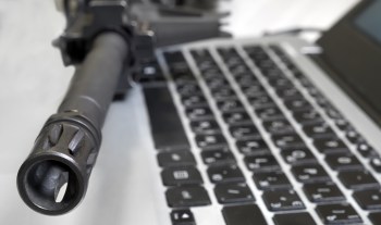 A gun on top of a laptop.
