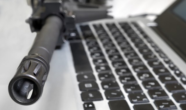 A gun on top of a laptop.