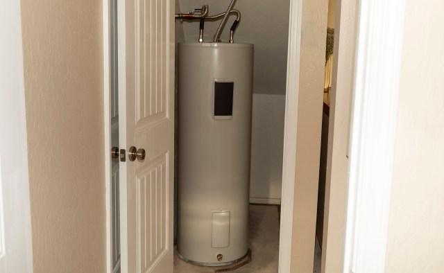 A water heater is located in a small room with open doors leading to the hallway.