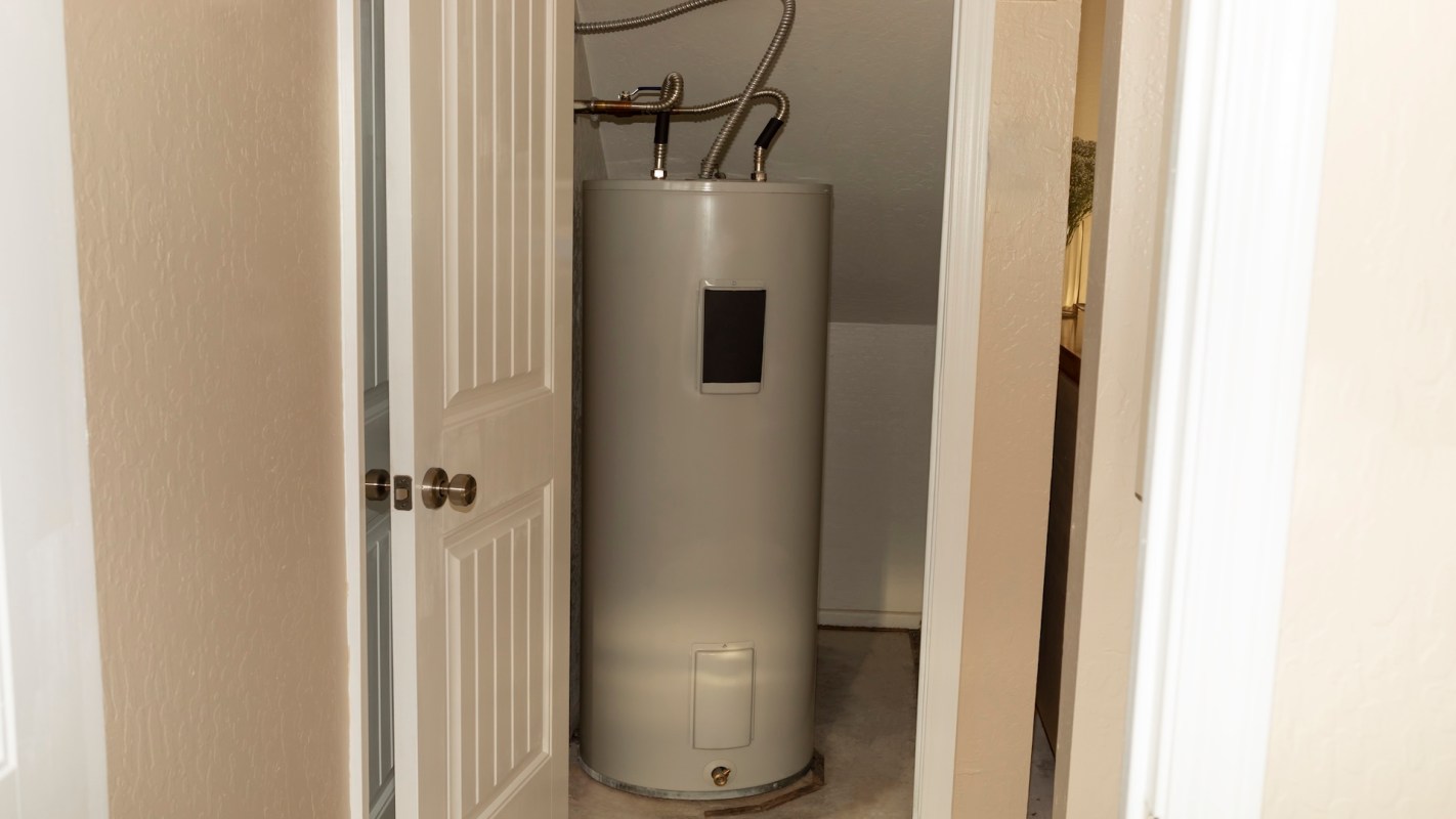 A water heater in a small closet with two doors slightly ajar.