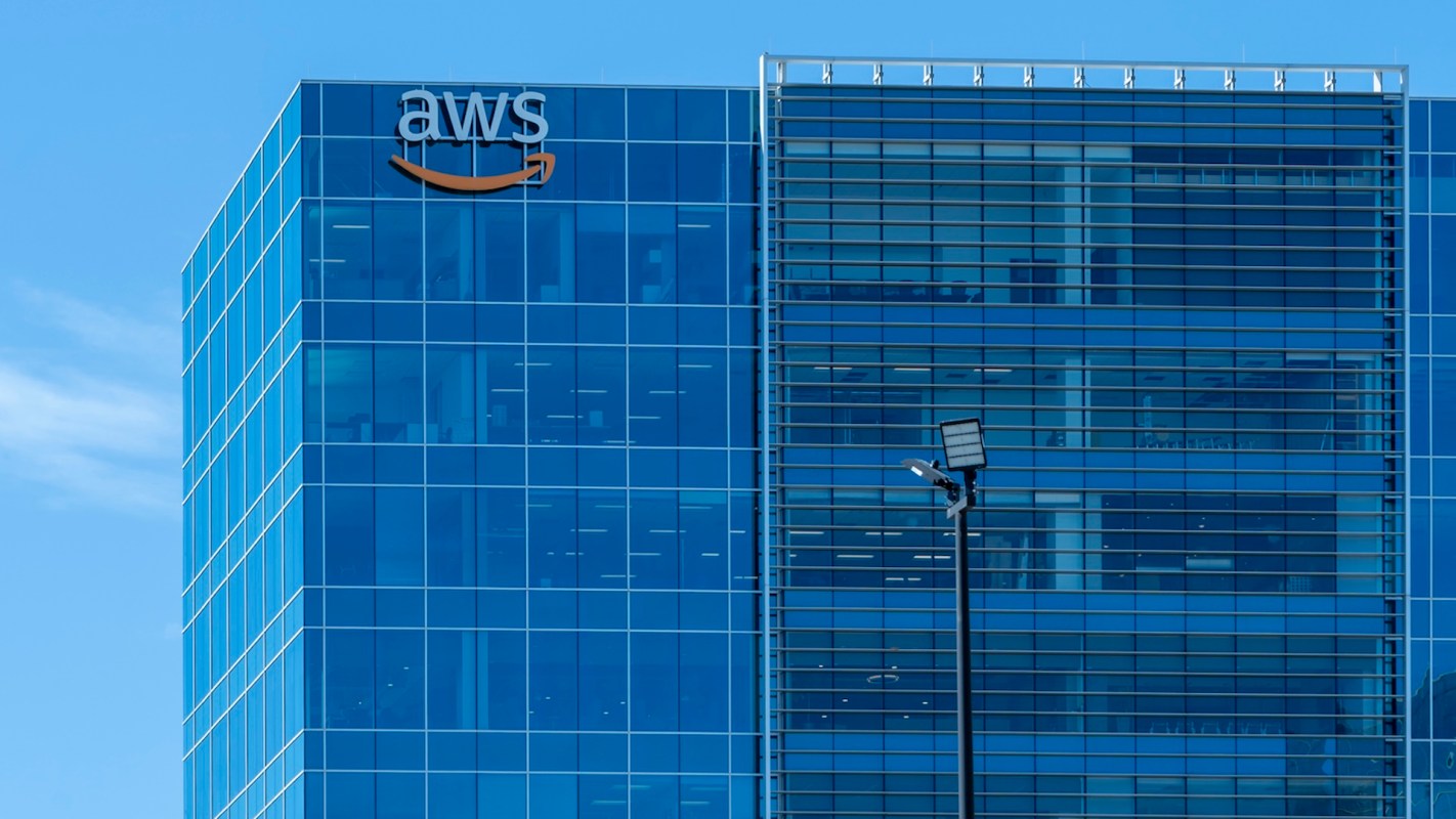 A modern building with large glass windows and an AWS logo on the façade.