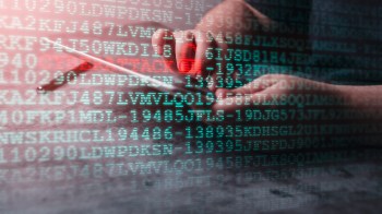 A hand holds a smartphone with digital code displayed in the background.