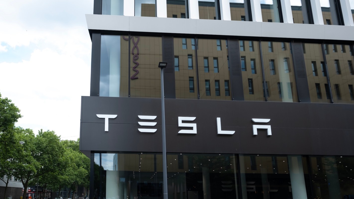 A Tesla store with large windows and a prominent company logo on the building.