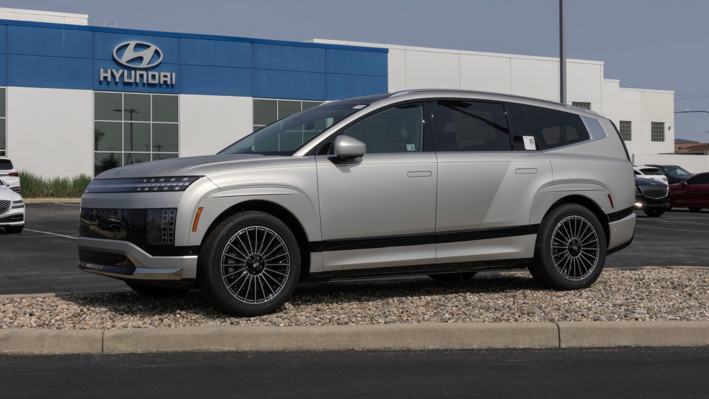 A silver Ioniq 9 SUV parked in front of a Hyundai dealership.