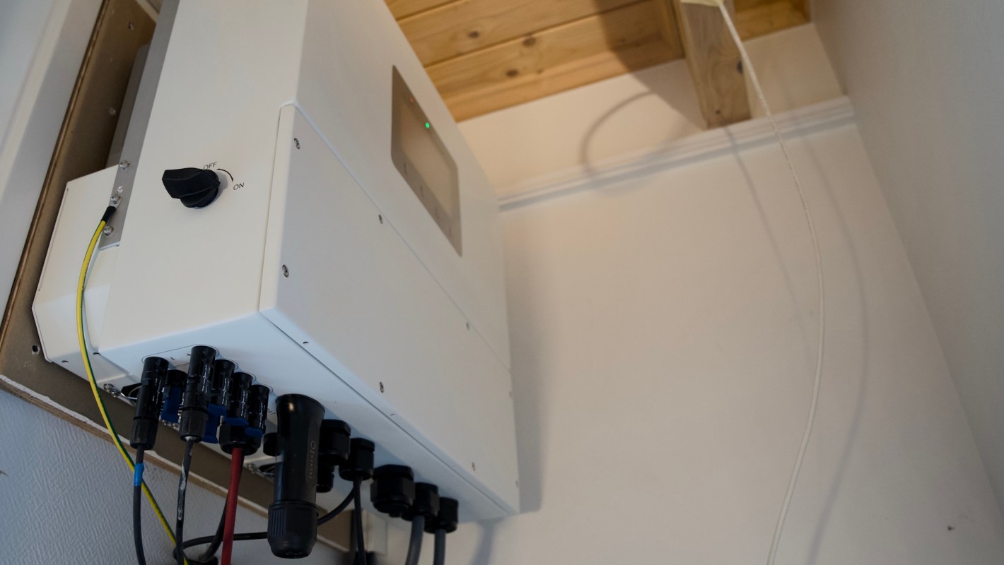 A wall-mounted electrical device with connectors and wiring.