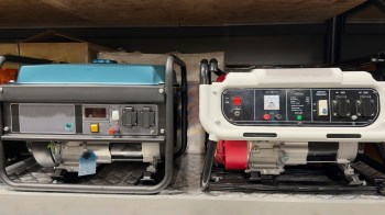 Two gasoline generators with displays and controls, positioned on a shelf in a storage area.