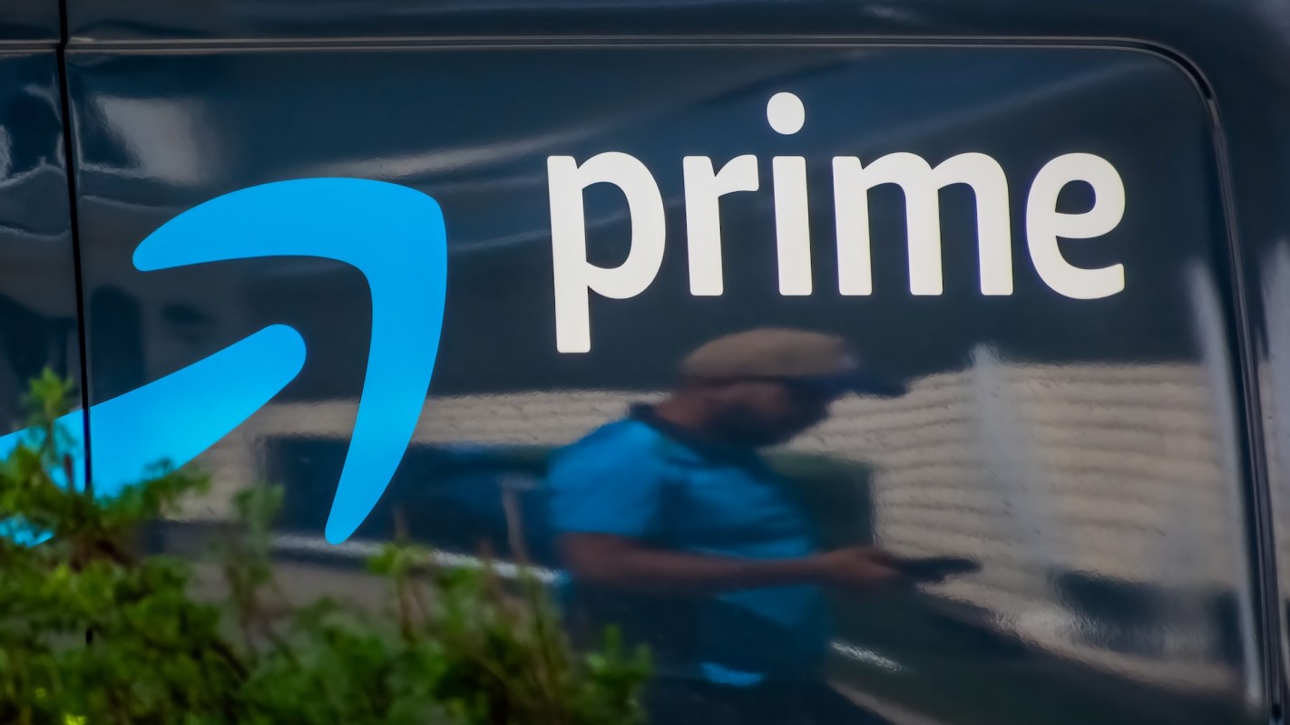 A delivery van featuring the "Prime" logo with a reflection of a person nearby.