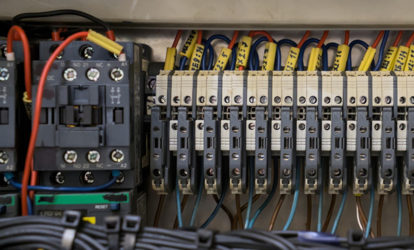 A collection of electrical relays and circuit breakers mounted within a control panel.