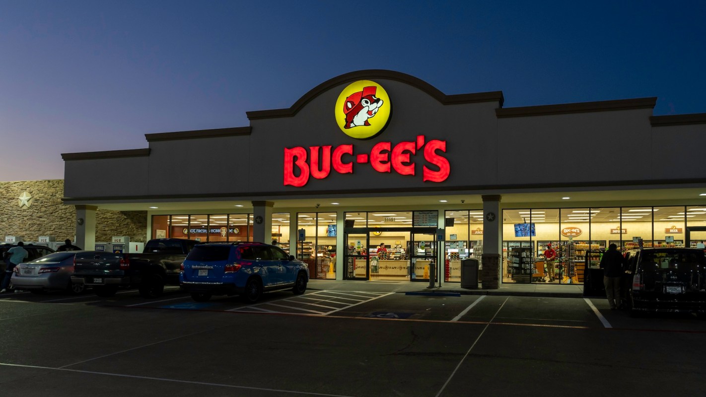 A Buc-ee's convenience store with bright signage and parked cars at dusk.