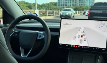 A view of a Tesla dashboard showing navigation and traffic information while in a self-driving mode.