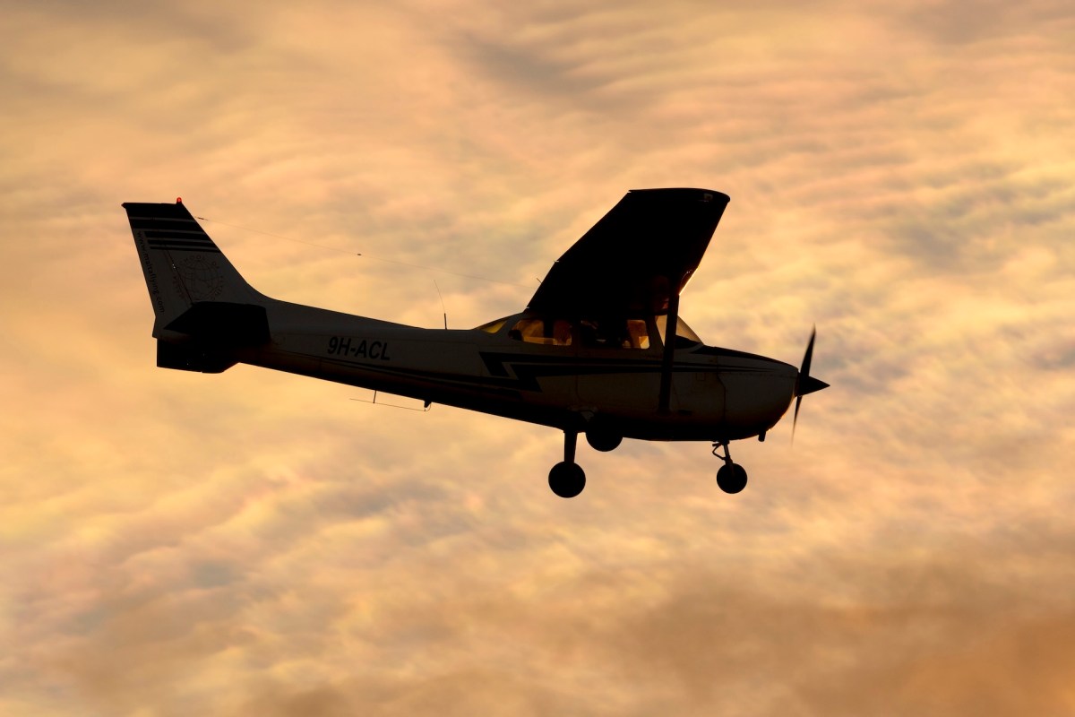 An airplane flying against a colorful sunset sky.
