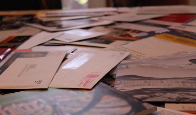 A collection of assorted envelopes and papers spread out on a table.