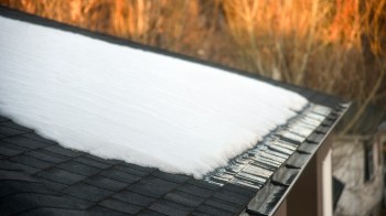 A snow-covered roof with melting snow along the edges.
