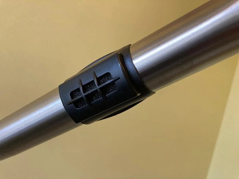 A metal vacuum wand with a vented ring.