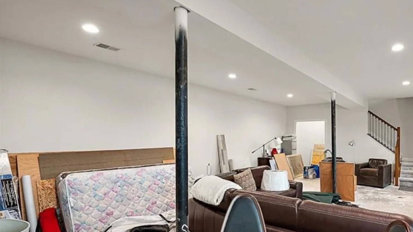 A cluttered basement with furniture.