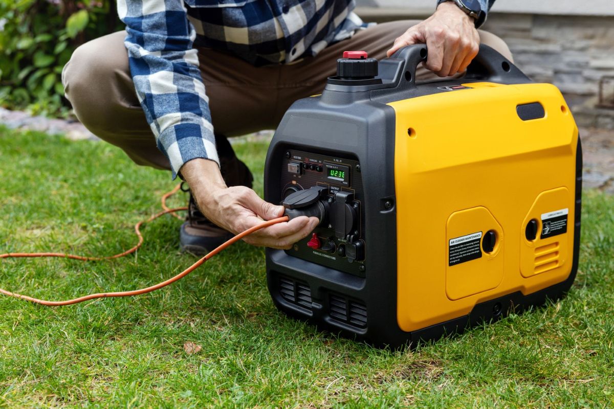 A man connecting cables to a portable inverter generator.