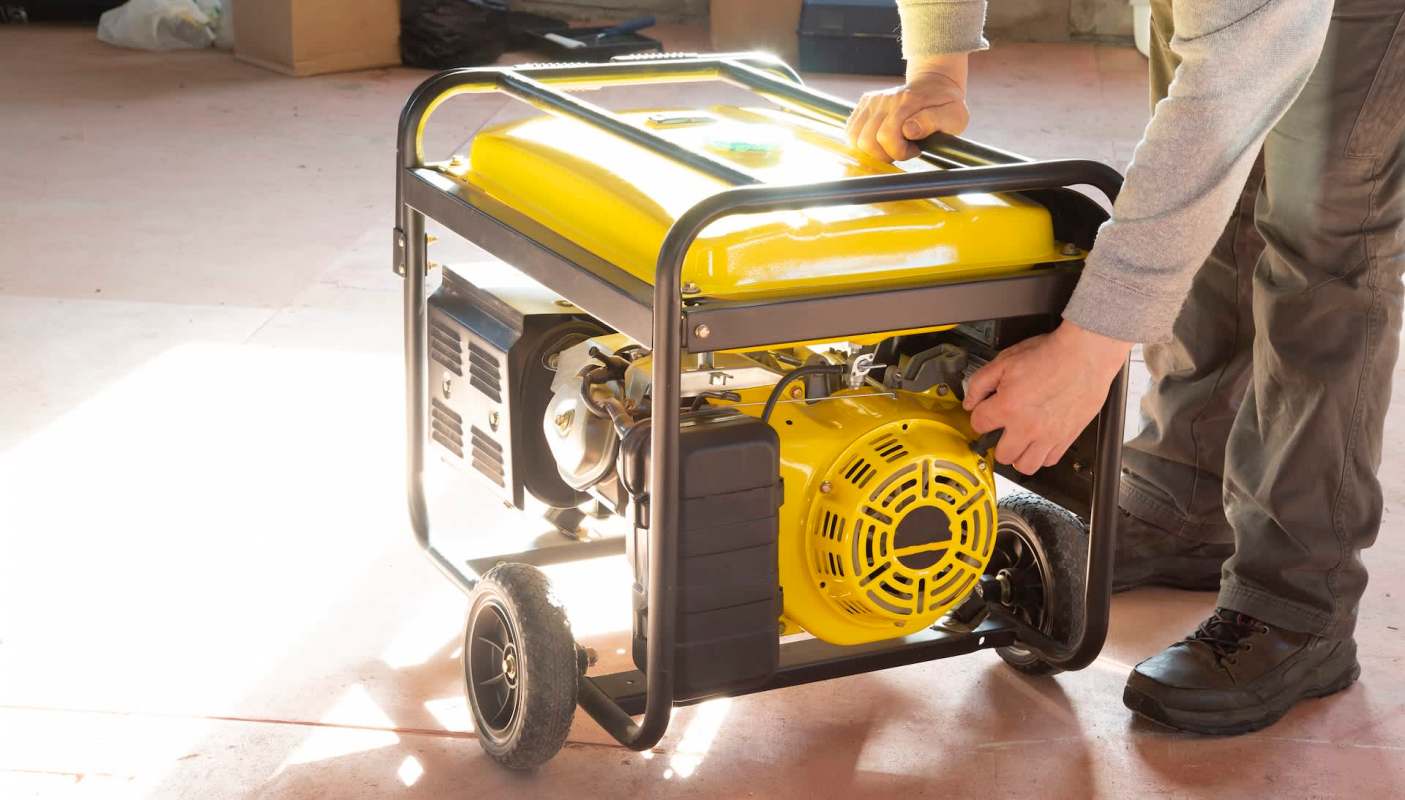 A person operating a yellow generator.