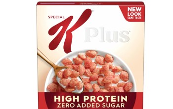 A box of Special K Plus cereal touting no added sugar, with a bowl of cereal and a spoon filled with pink puffed grains.