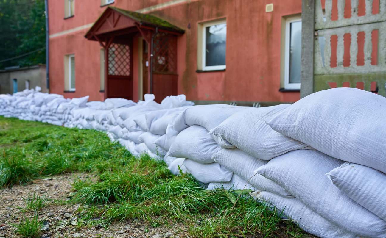 A row of white sandbags lined up in front of a building.