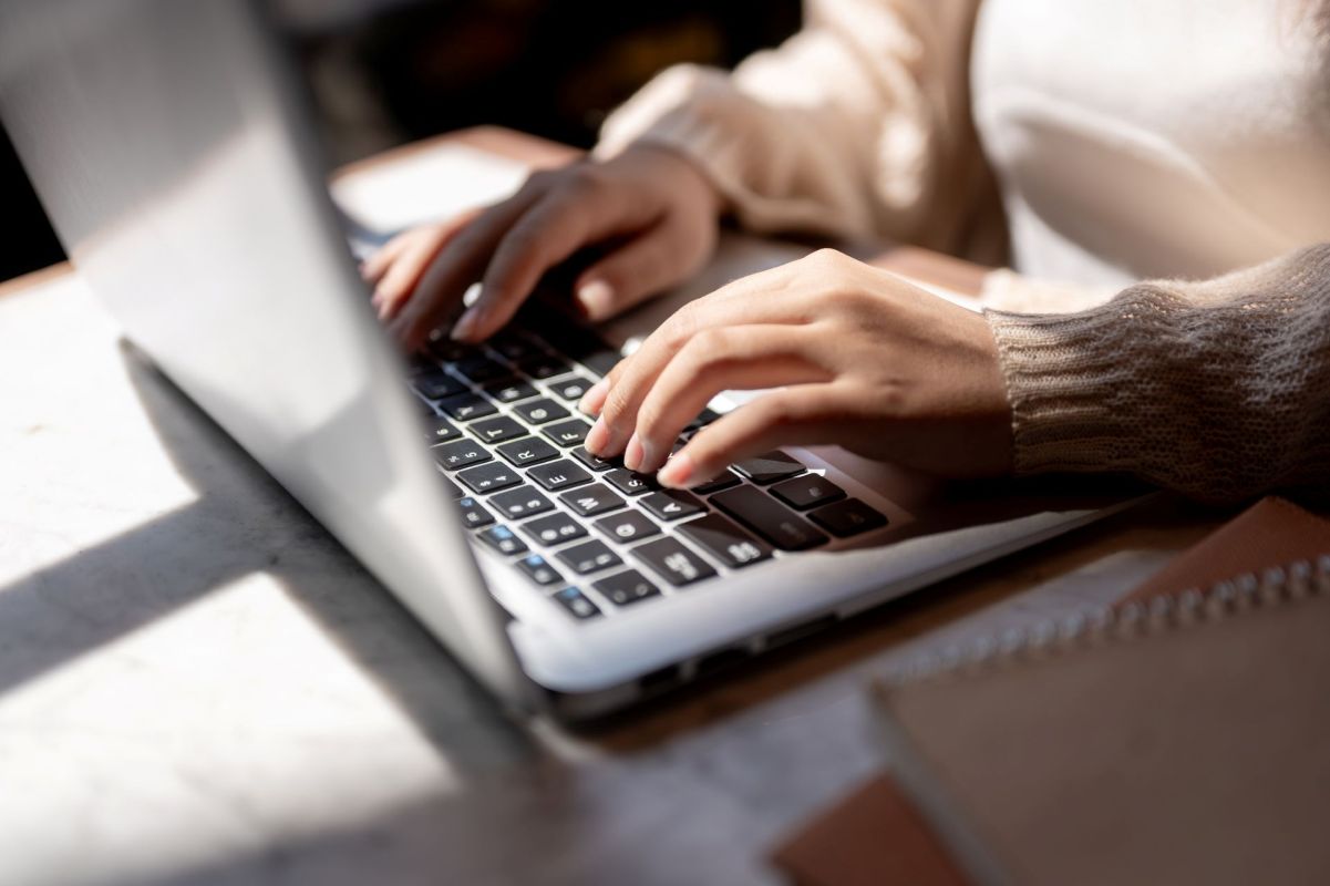 A woman typing on a laptop.