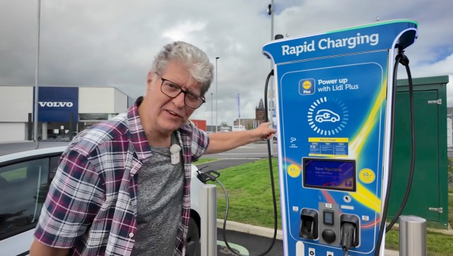A man points to a Lidl rapid charging station for electric vehicles.