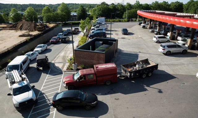 Cars lined up at a gas station.