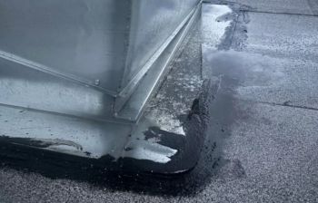 Water pooling around the base of a metal structure on a flat surface.