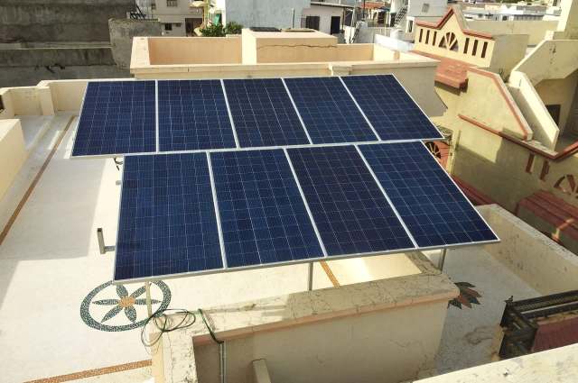 A rooftop solar panel sits atop a house in India