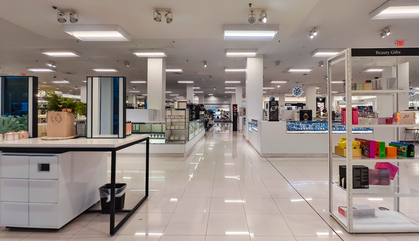 A spacious retail store interior featuring display counters and shelves with various beauty products.