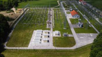 An aerial view of a power substation with various equipment and multiple electrical lines.