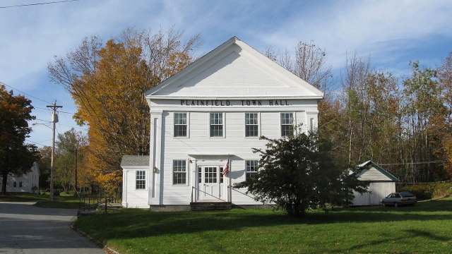 A white building labeled "Plainfield Town Hall" with trees and a small shed nearby.