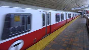 A train moves through a subway station.