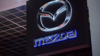 Mazda logo displayed prominently on a dark background with illuminated elements.