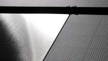 A partial view of solar panels reflecting light.