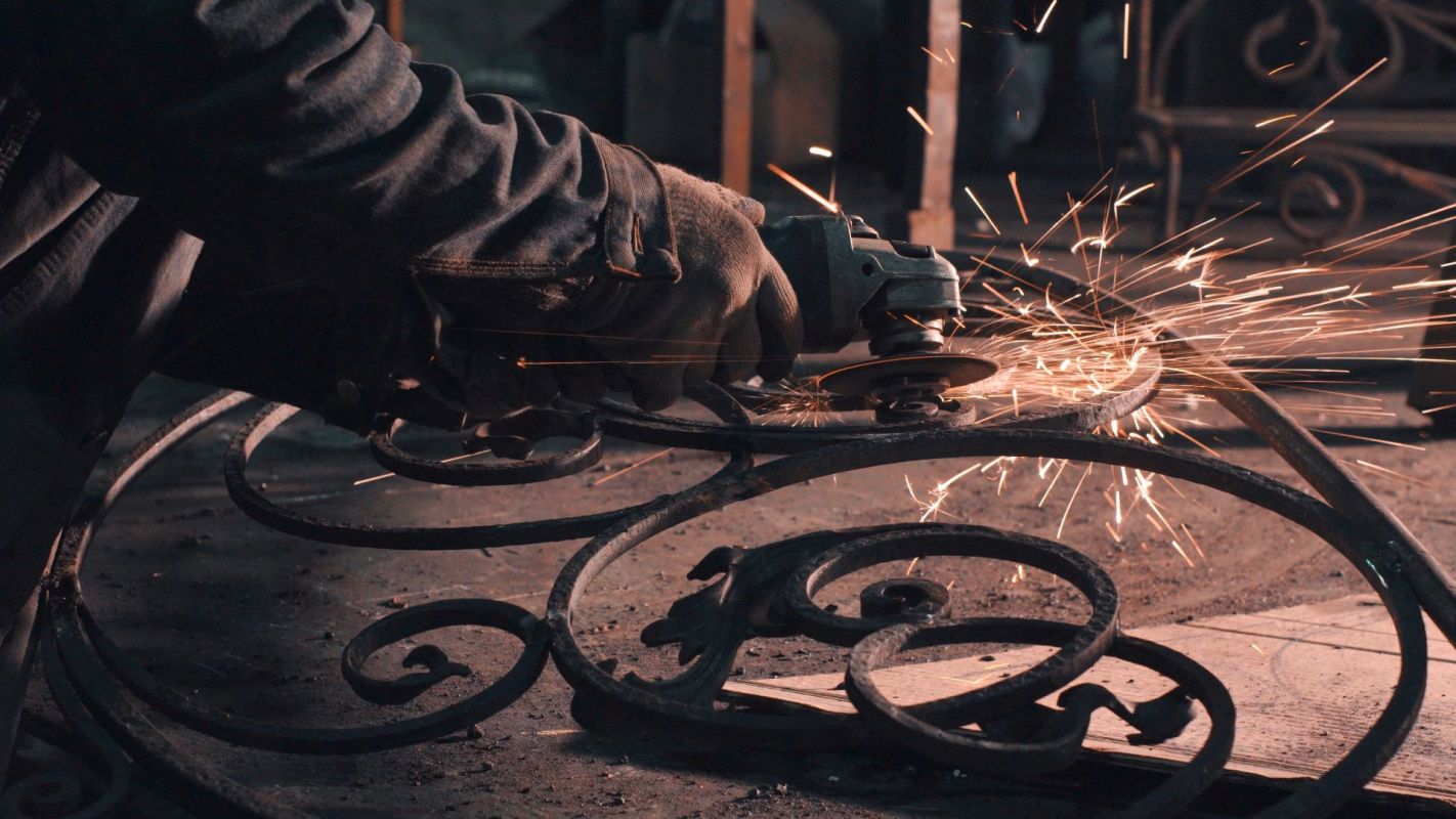 A person working on a metal grate.