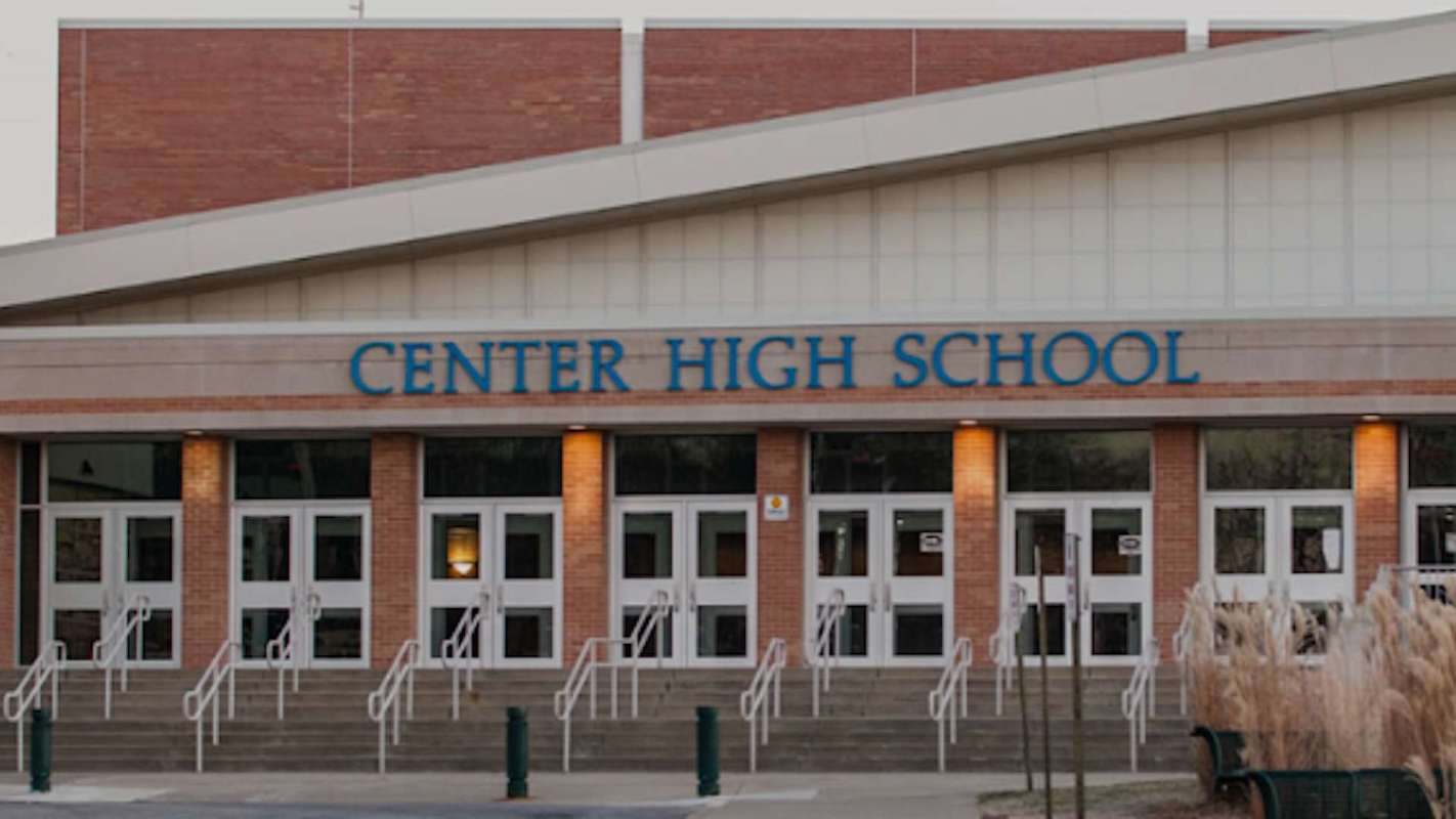 The entrance of Center High School with multiple doors and stairs leading up to it.