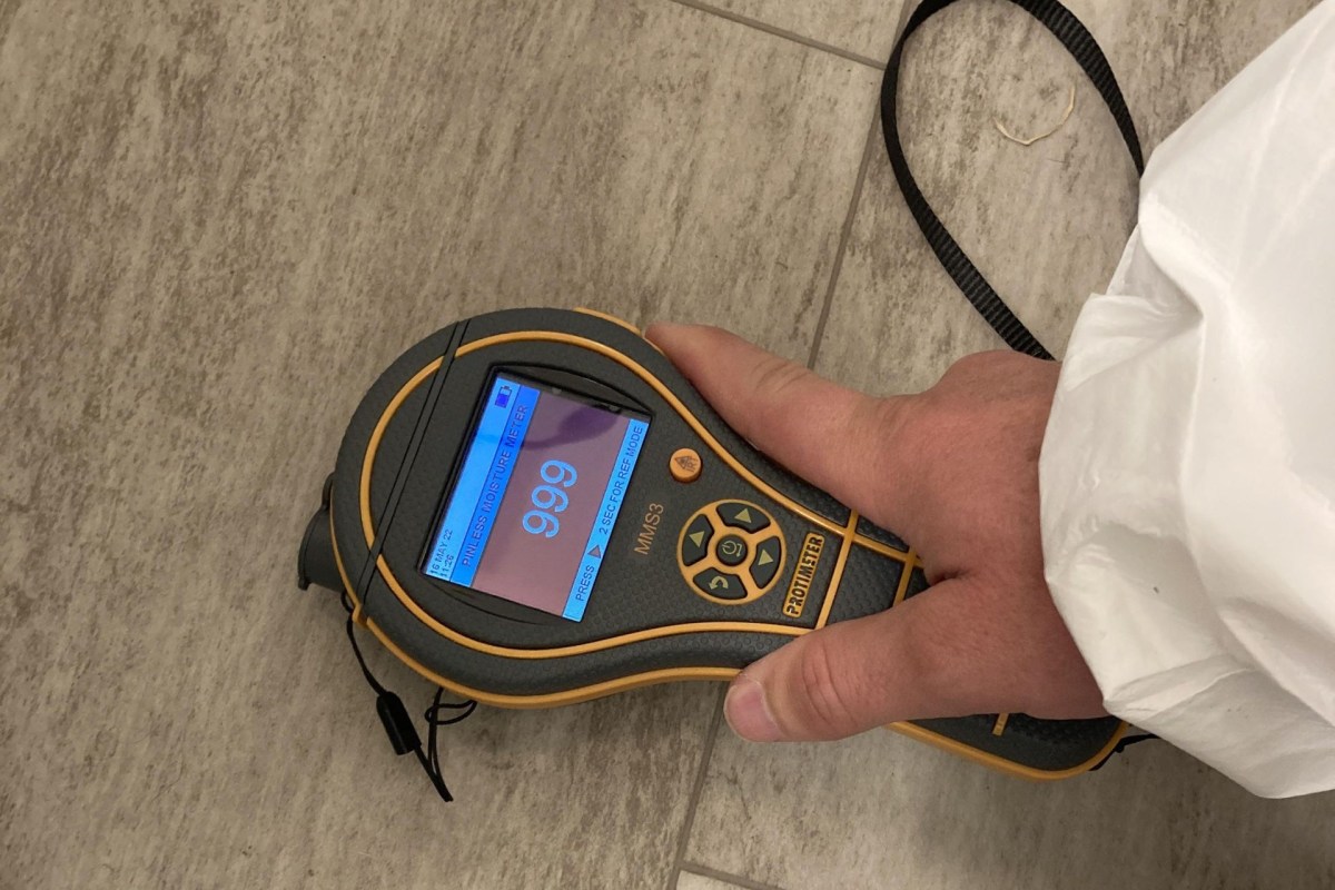 A mold inspector using a hydrometer.