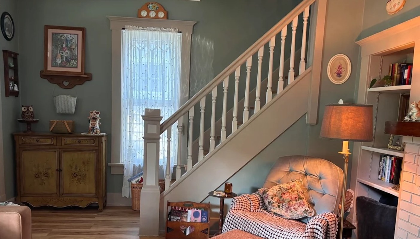 A picture of an armchair in the living room, with stairs in the background.