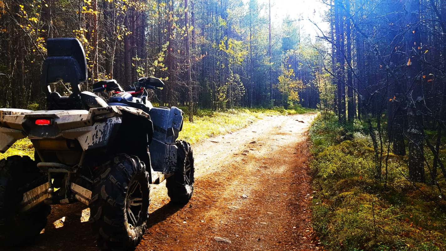 An all-terrain vehicle parked on a forest path.