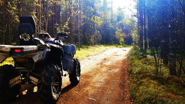 An all-terrain vehicle parked on a forest path.