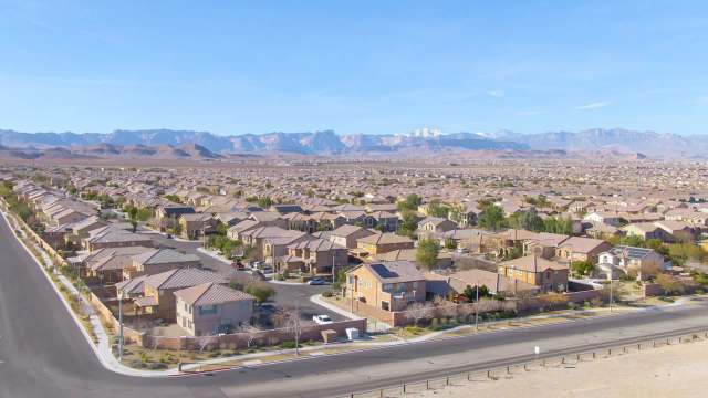 Aerial view of a residential Nevada neighborhood with houses and mountains in the background.