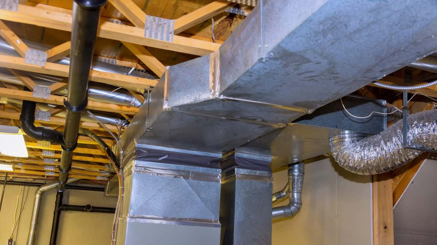 Ductwork and piping installed on the ceiling of a basement.