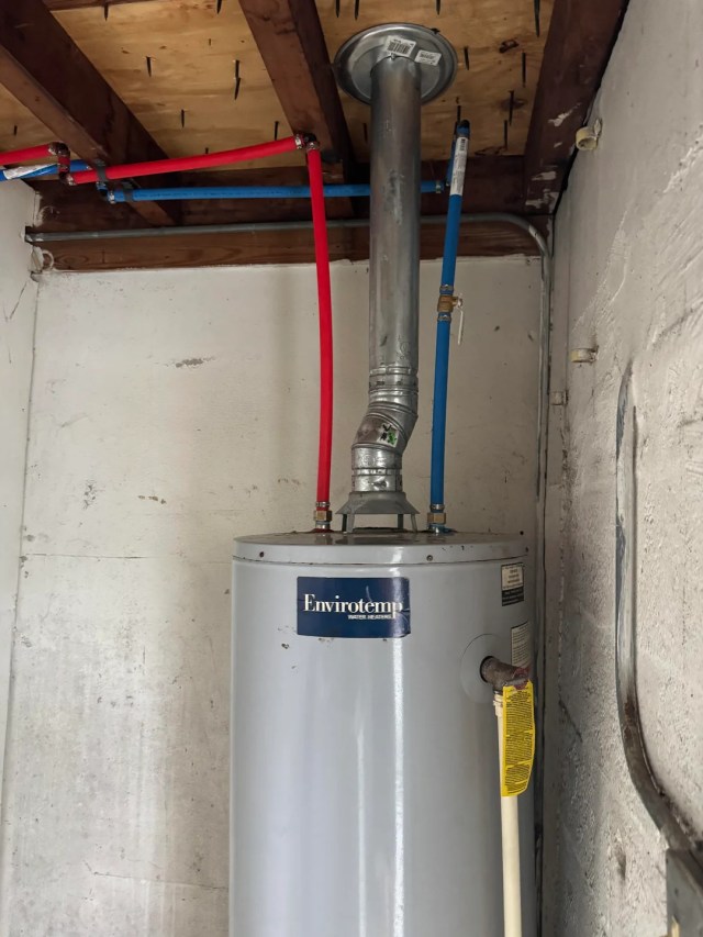 Blue and red pipes connected to a water heater.