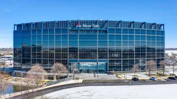 A modern office building with reflective glass windows and a sign for Nicor Gas.